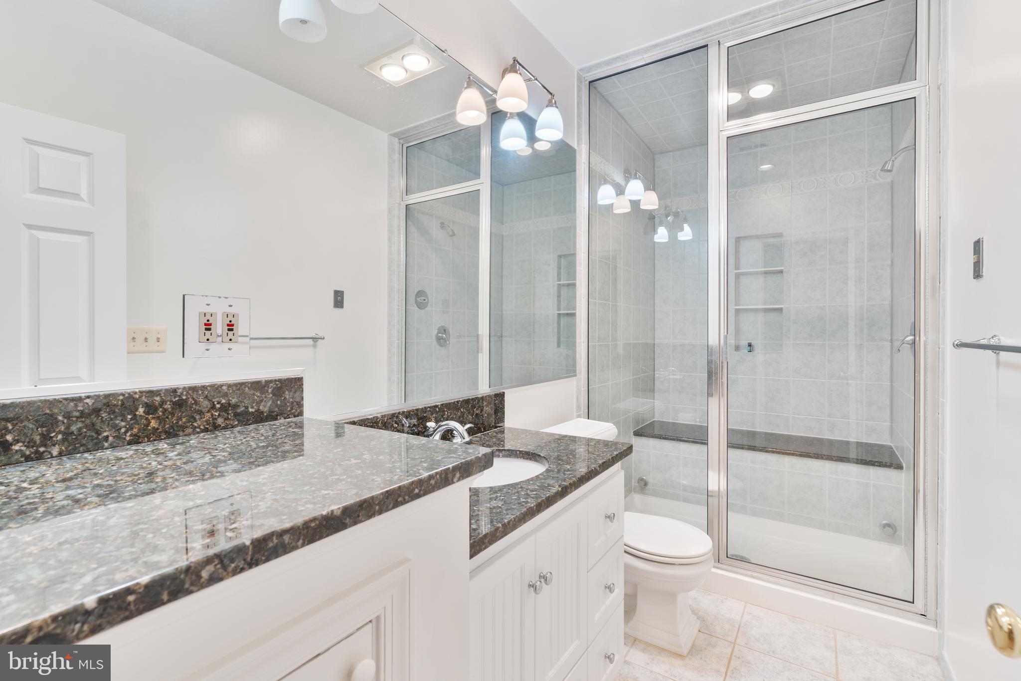 7815 Stable Way Potomac, MD 20854 - Photo 27 of 36 a bathroom with a granite countertop sink a toilet a mirror and shower