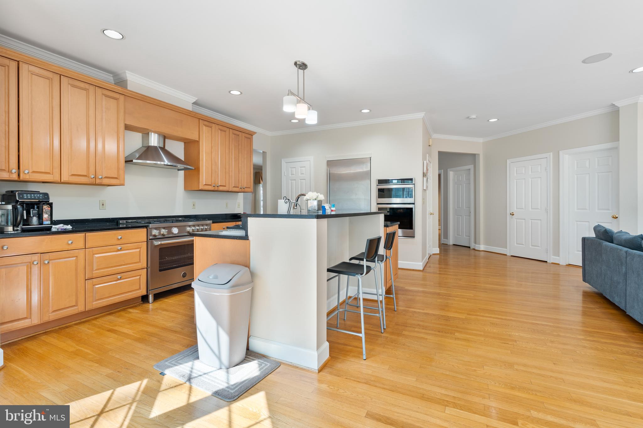 7815 Stable Way Potomac, MD 20854 - Photo 9 of 36 a kitchen with stainless steel appliances granite countertop a stove top oven a sink a dining table and chairs with wooden floor
