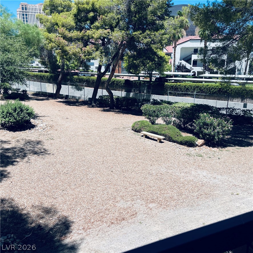 260 East Flamingo Road, Unit 118 Las Vegas, NV 89169 - Photo 3 of 9 A tranquil, rock-filled yard with mature trees and a serene sitting bench.