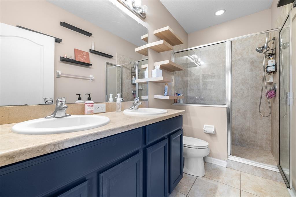962 Sombra Street Tampa, FL 33619 - Photo 18 of 24 a bathroom with a double vanity sink mirror and shower