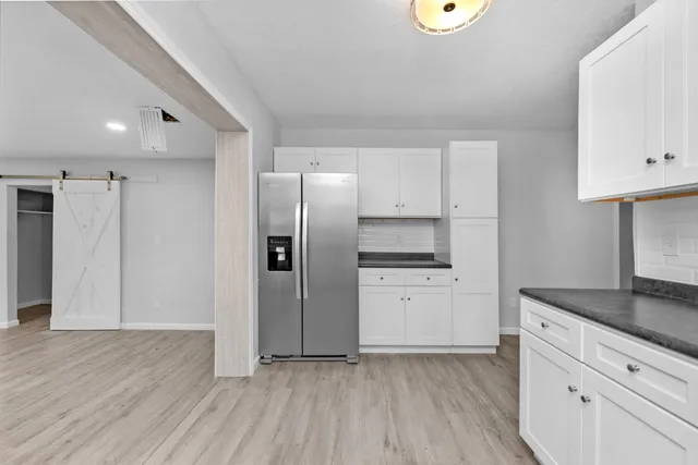 a kitchen with stainless steel appliances granite countertop a refrigerator and a stove top oven