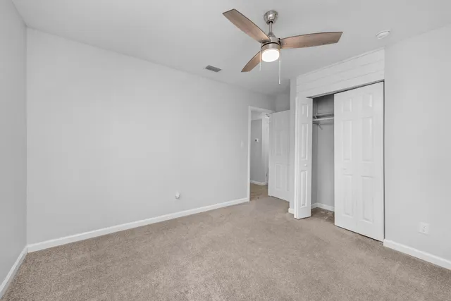 an empty room with closet and fan