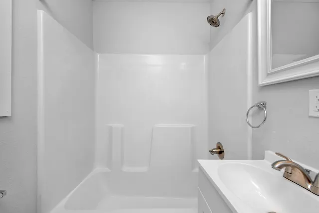 a bath room with a sink and mirror