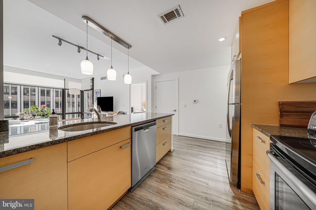 a large kitchen with stainless steel appliances a large counter top