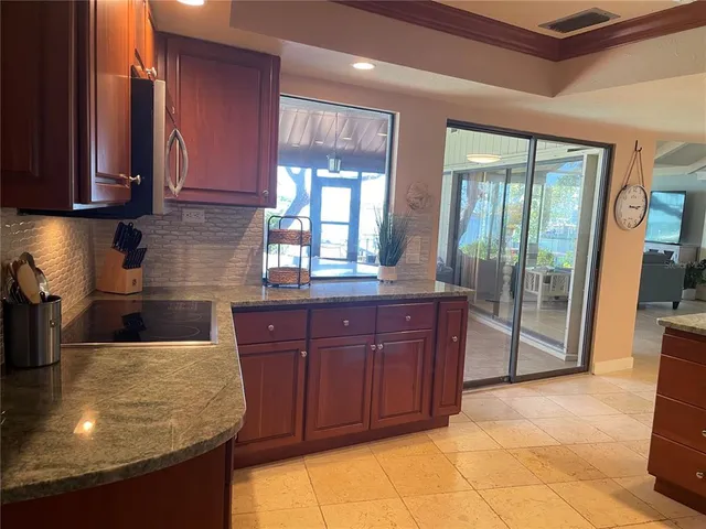 a kitchen with granite countertop a stove a sink and a cabinets