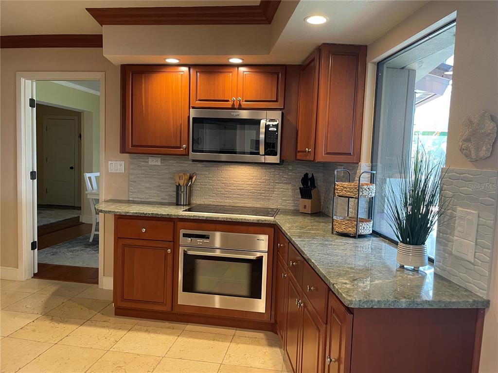 421 Waterside Lane Nokomis, FL 34275 - Photo 18 of 48 a kitchen with stainless steel appliances granite countertop a sink and a microwave