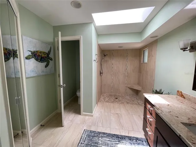 a bathroom with a granite countertop sink and shower