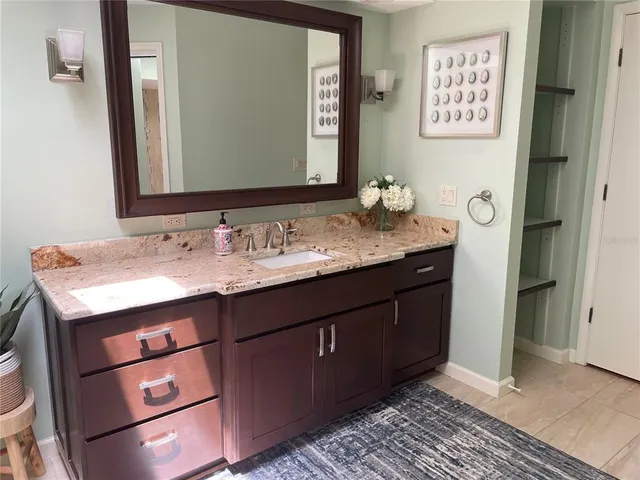 a bathroom with a granite countertop sink and a mirror