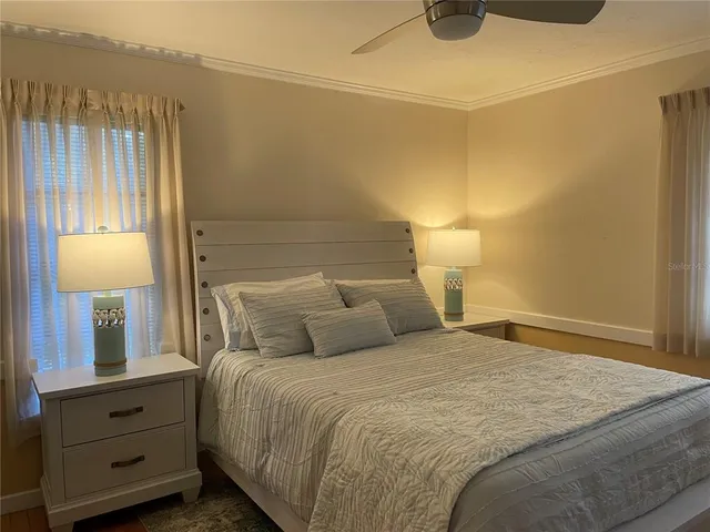 a bedroom with a bed and a lamp on the dresser