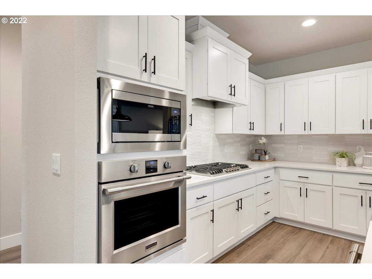 8534 North 5th Street, Unit LT 32 Ridgefield, WA 98642 - Photo 5 of 26 a kitchen with stainless steel appliances granite countertop a stove a sink and a microwave