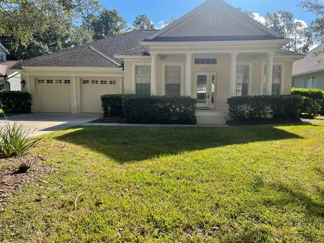 a view of a house with swimming pool lawn chairs and potted plants
