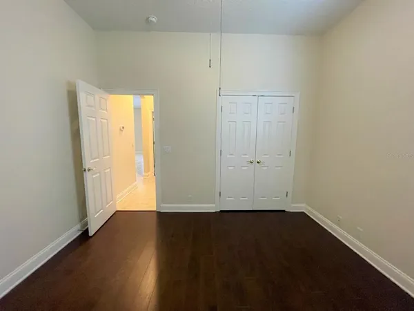 an empty room with wooden floor and white doors