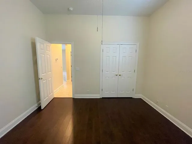 an empty room with wooden floor and white doors