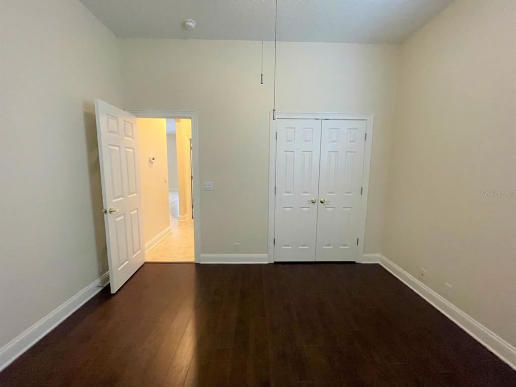 8447 Bowden Way Windermere, FL 34786 - Photo 12 of 21 an empty room with wooden floor and white doors