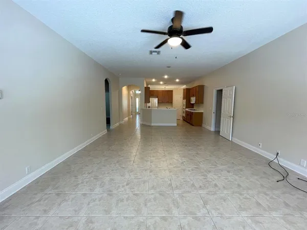 a view of a livingroom with a ceiling fan and kitchen view