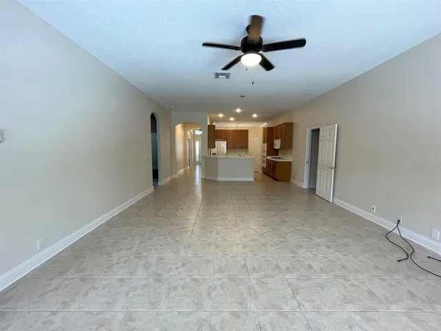 a view of a livingroom with a ceiling fan and kitchen view