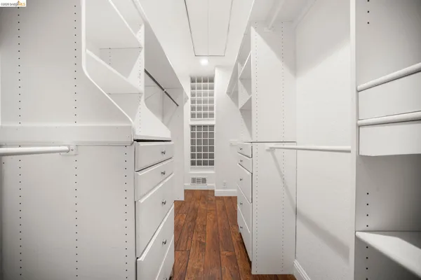 a view of walk in closet with wooden floor
