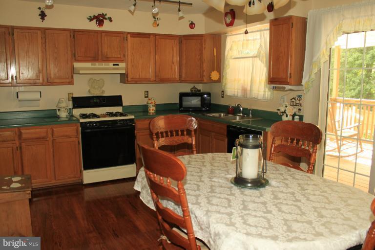 96 Yew Road Baltimore, MD 21221 - Photo 6 of 25 a kitchen with a stove a sink and a microwave