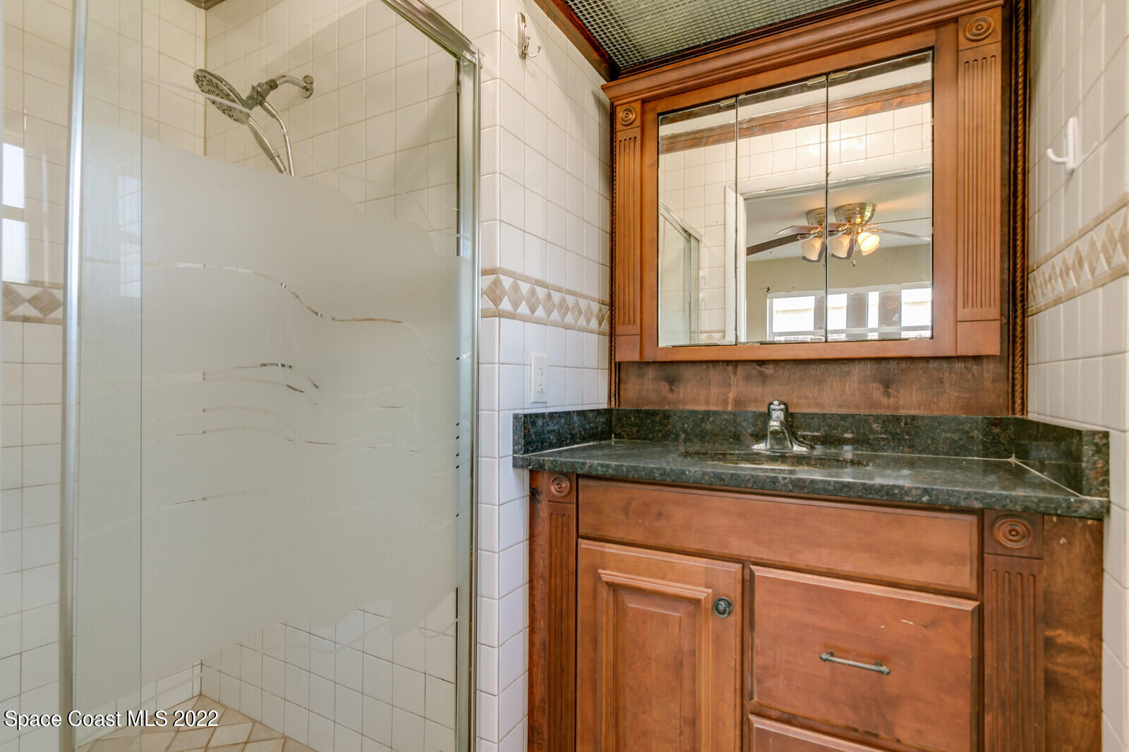 2655 Sarno Road Melbourne, FL 32935 - Photo 13 of 18 a bathroom with a granite countertop sink a vanity and a shower