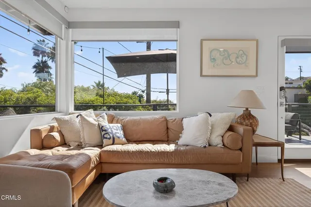 a outdoor dining room with furniture potted plants and wooden floor