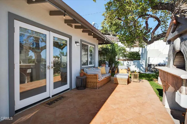 a backyard of a house with table and chairs and potted plants