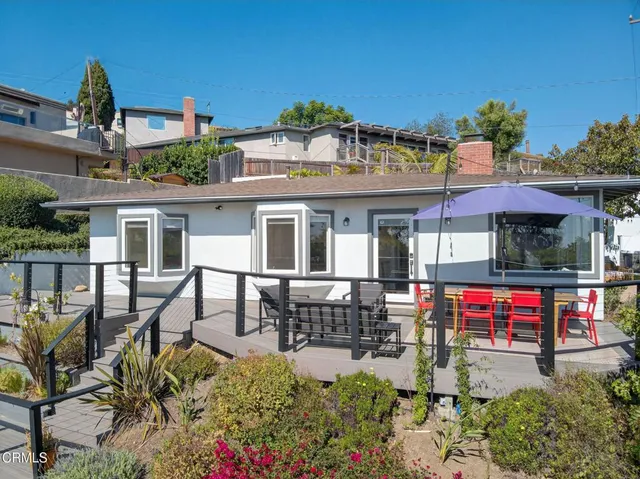 a view of a patio with table and chairs under an umbrella