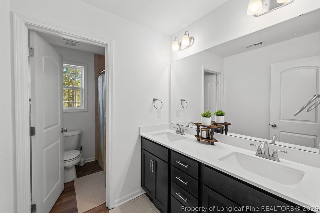 6915 Wickersham Road Fayetteville, NC 28314 - Photo 12 of 25 a bathroom with a double vanity sink and a mirror
