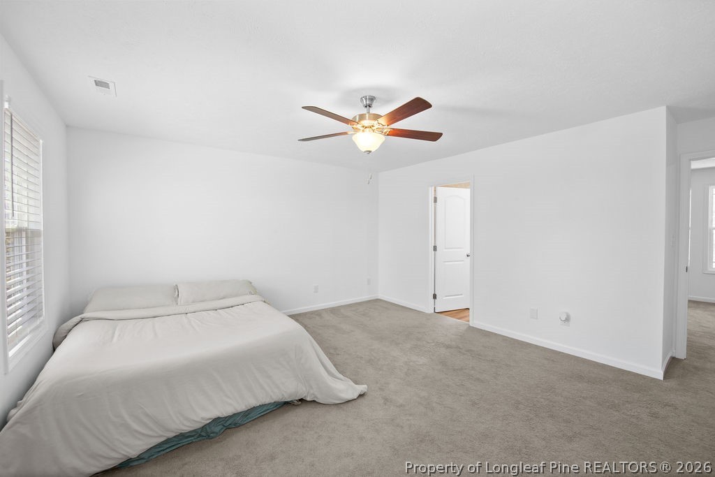6915 Wickersham Road Fayetteville, NC 28314 - Photo 18 of 25 a bedroom with a bed and a ceiling fan