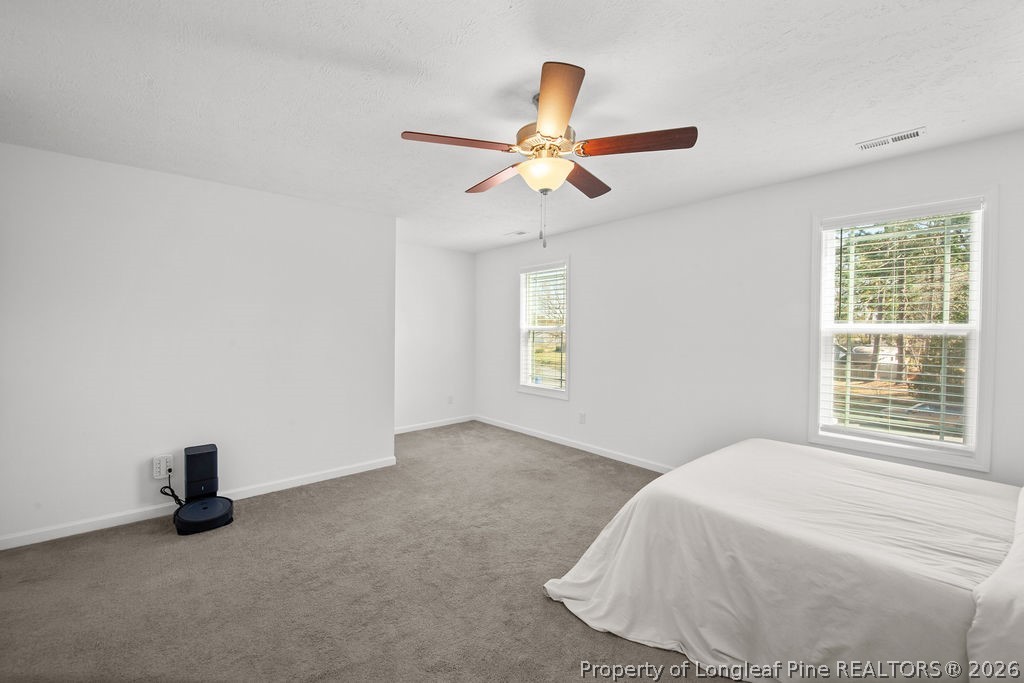 6915 Wickersham Road Fayetteville, NC 28314 - Photo 19 of 25 a bedroom with a bed and a ceiling fan