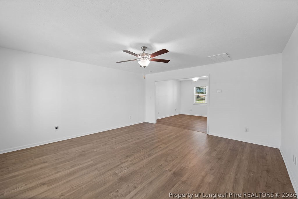 6915 Wickersham Road Fayetteville, NC 28314 - Photo 2 of 25 an empty room with wooden floor and ceiling fan