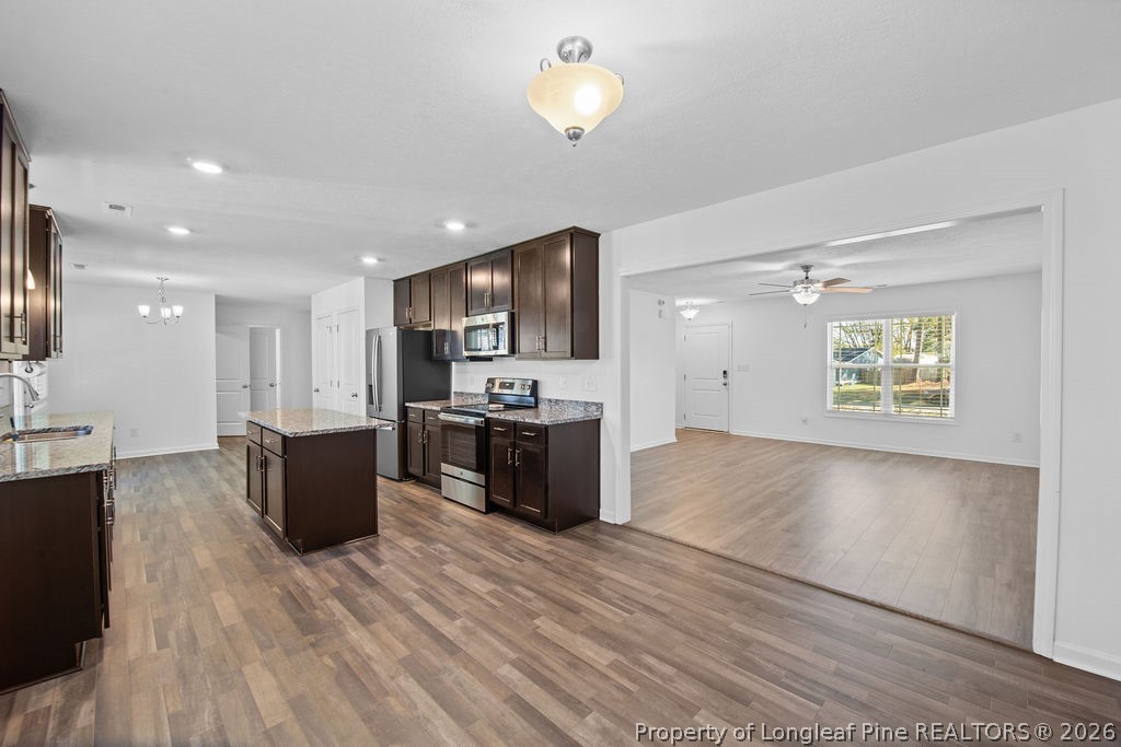 6915 Wickersham Road Fayetteville, NC 28314 - Photo 5 of 25 a large kitchen with stainless steel appliances kitchen island a large counter top and a wooden floors