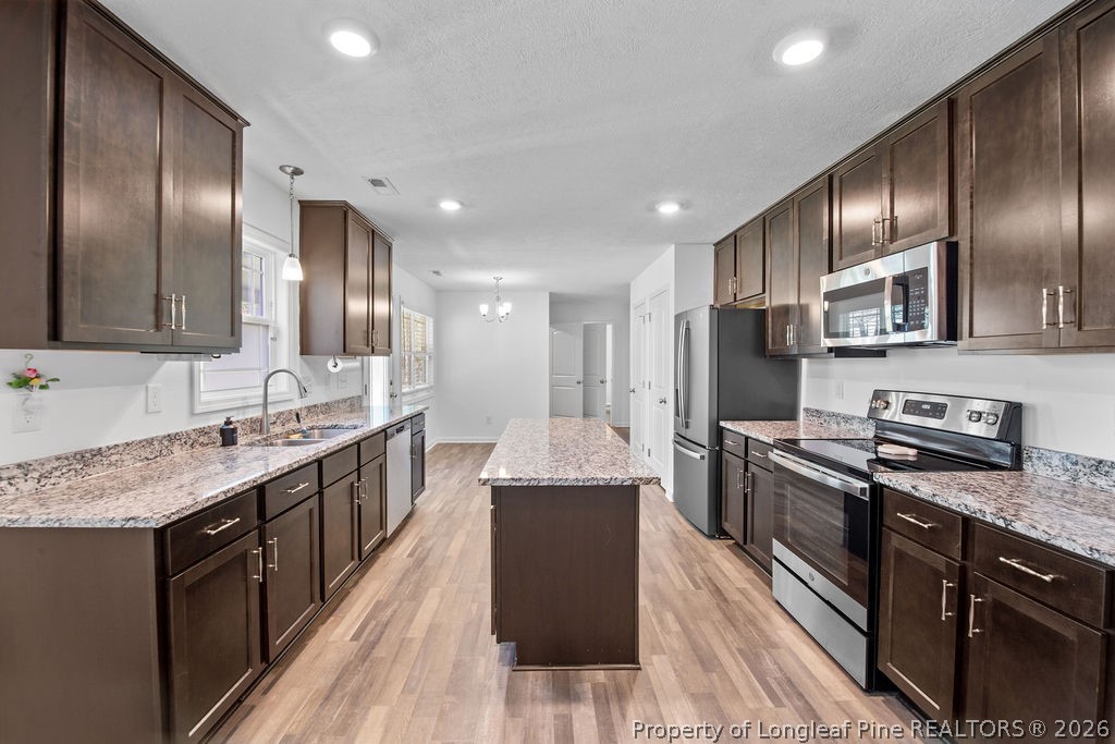 6915 Wickersham Road Fayetteville, NC 28314 - Photo 6 of 25 a kitchen with stainless steel appliances granite countertop refrigerator a sink a stove and wooden cabinets