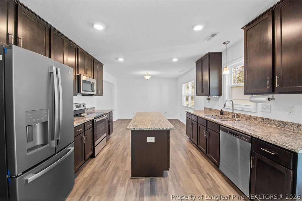 6915 Wickersham Road Fayetteville, NC 28314 - Photo 7 of 25 a kitchen with stainless steel appliances granite countertop a refrigerator a stove top oven and sink