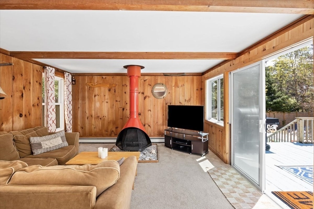 35 Tecumseh Road Wellfleet, MA 02667 - Photo 7 of 24 a living room with furniture a flat screen tv and a floor to ceiling window