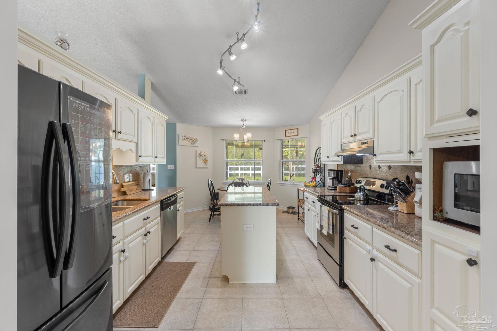 8046 Castle Pointe Way Pensacola, FL 32506 - Photo 12 of 40 a kitchen with stainless steel appliances a stove sink refrigerator and cabinets