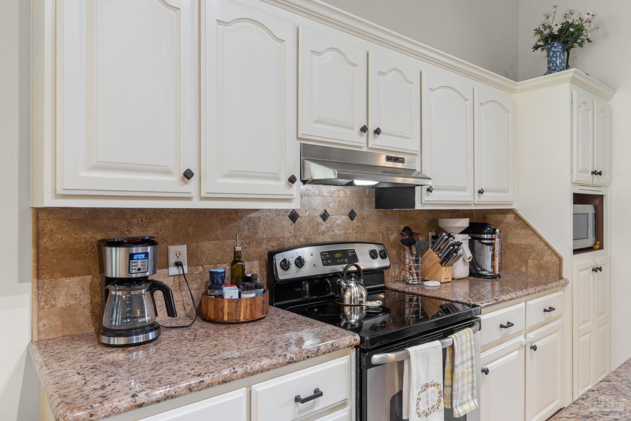 8046 Castle Pointe Way Pensacola, FL 32506 - Photo 13 of 40 a kitchen with granite countertop a sink a stove and cabinets
