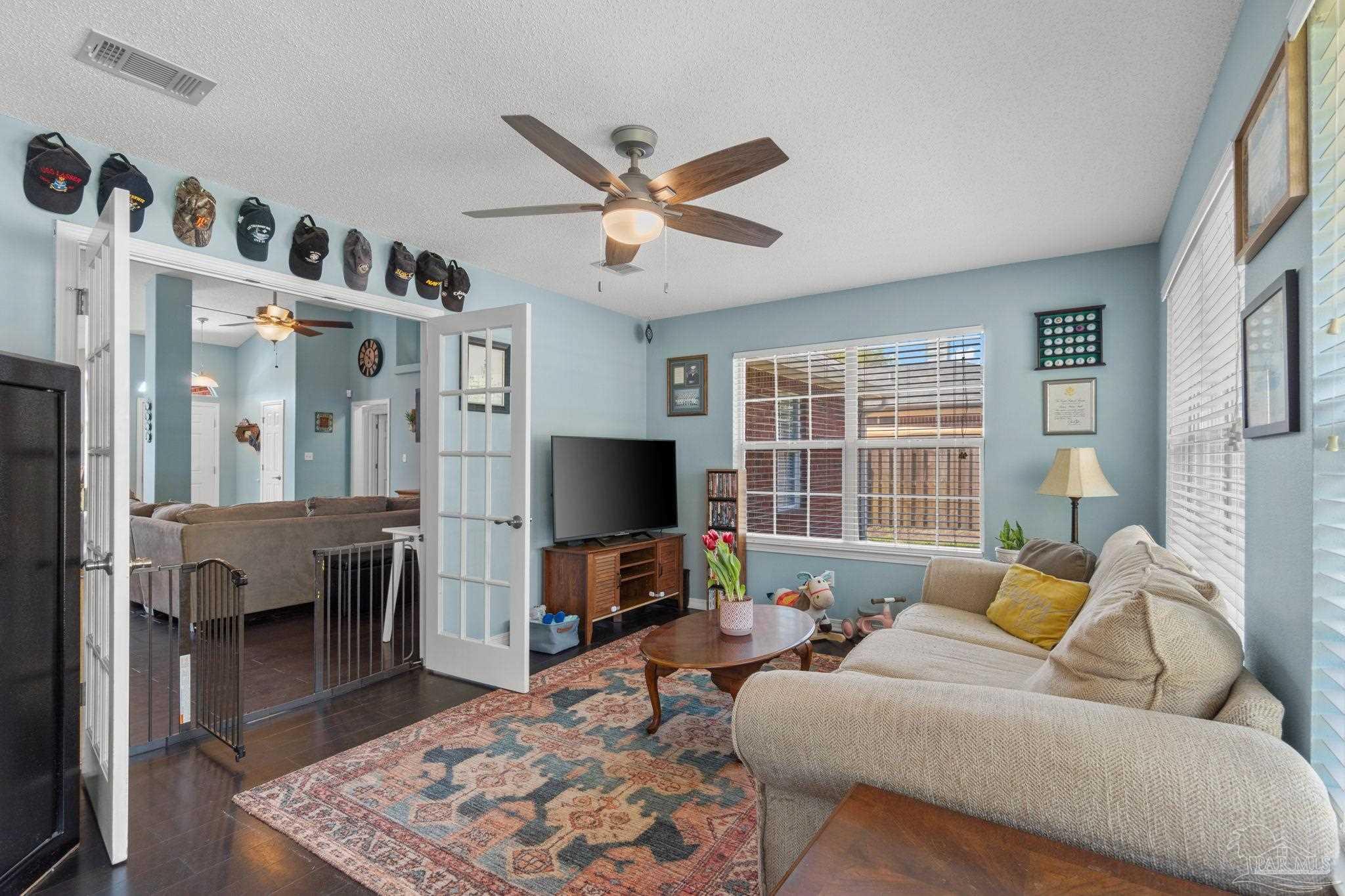 8046 Castle Pointe Way Pensacola, FL 32506 - Photo 16 of 40 a living room with furniture and a flat screen tv