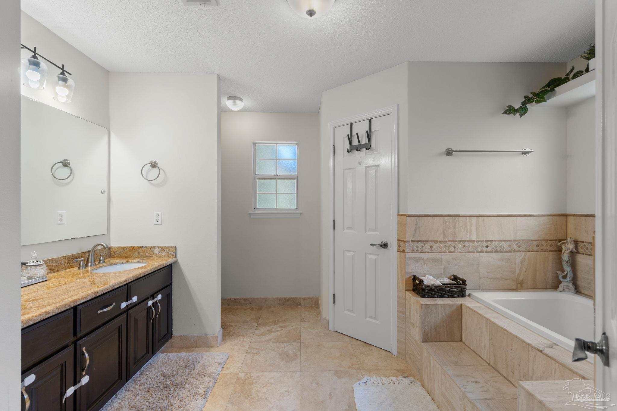 8046 Castle Pointe Way Pensacola, FL 32506 - Photo 23 of 40 a bathroom with a tub sink shower and mirror