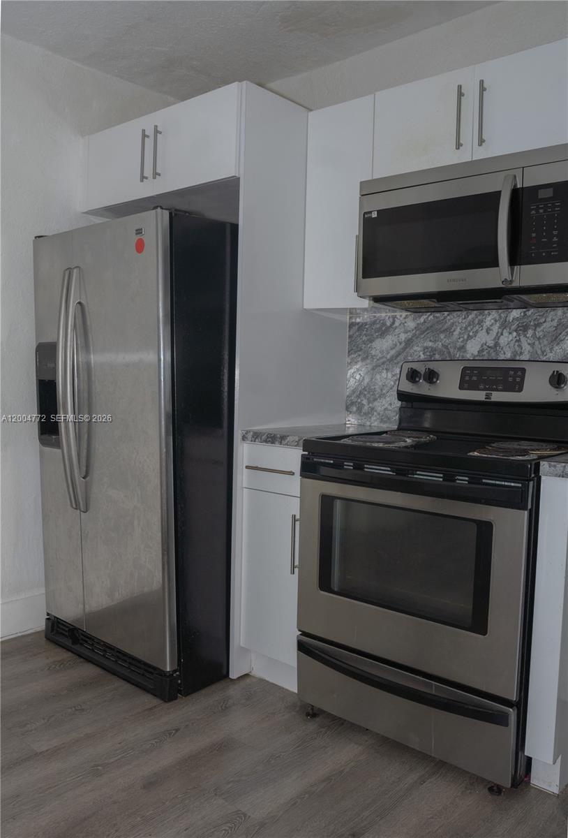 3376 Northwest 49th Street Miami, FL 33142 - Photo 13 of 17 a kitchen with stainless steel appliances and wooden cabinets