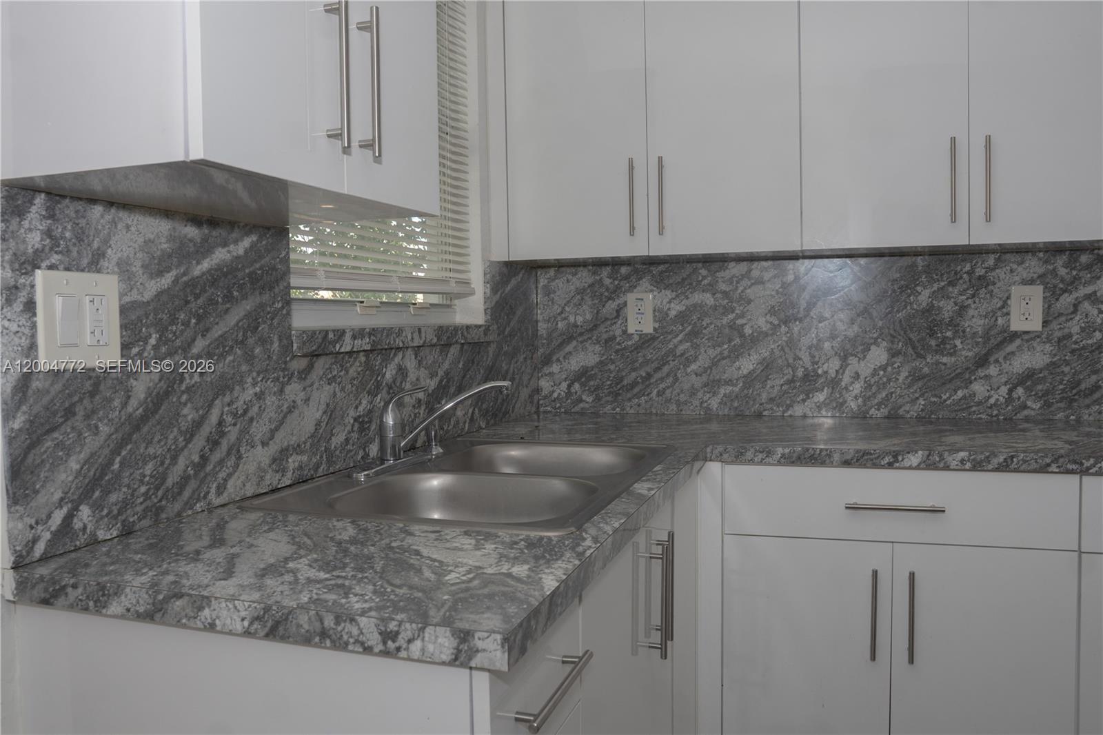 3376 Northwest 49th Street Miami, FL 33142 - Photo 10 of 17 a kitchen with granite countertop a sink and a stove