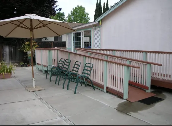 a view of a patio with a table and chairs under an umbrella