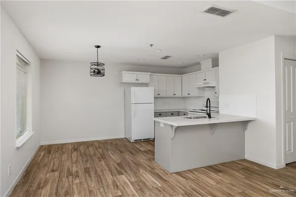 a kitchen with stainless steel appliances a sink cabinets and wooden floor