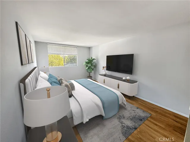 a spacious bedroom with a bed and a flat screen tv