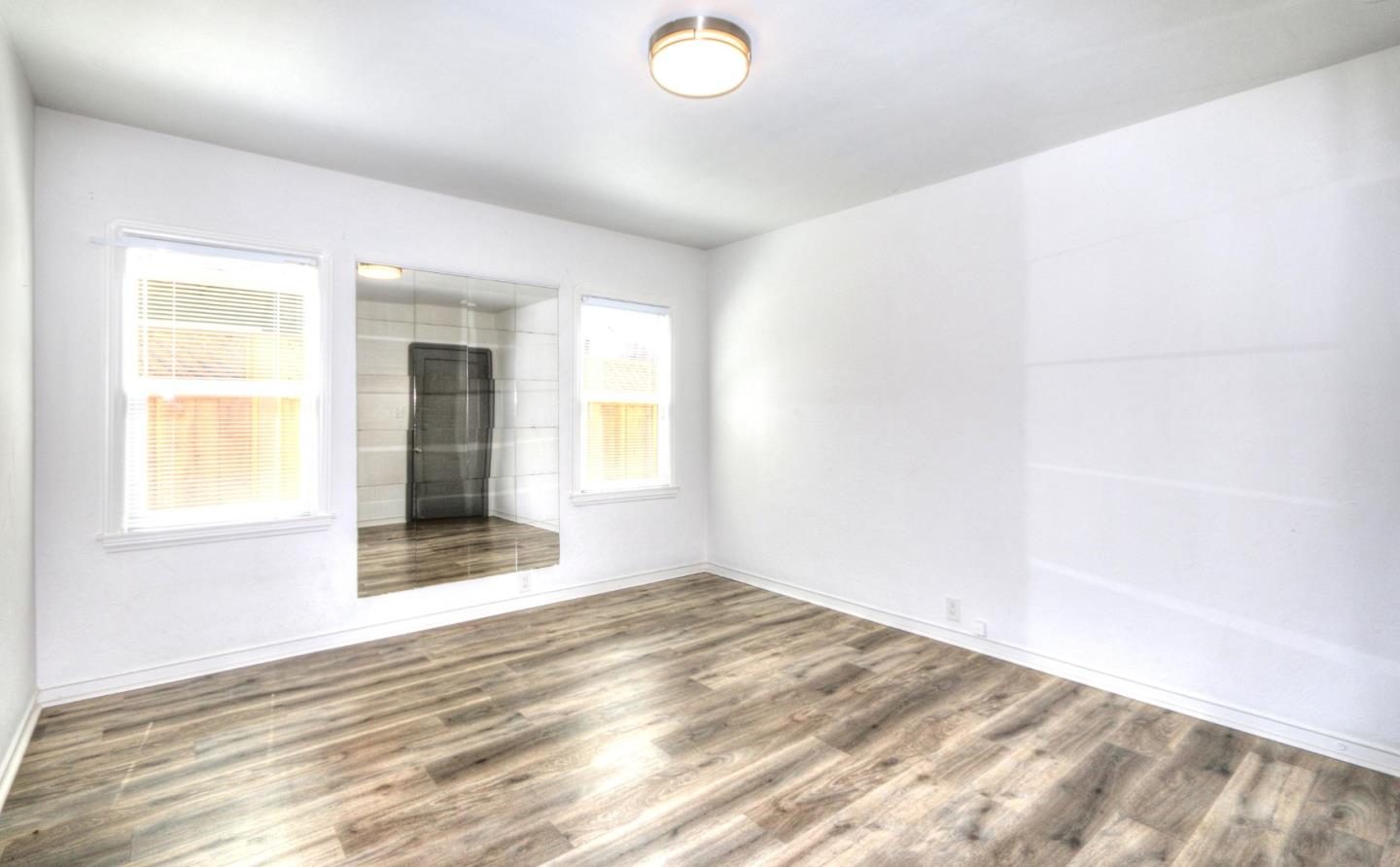 553 Rutland Avenue San Jose, CA 95128 - Photo 11 of 20 an empty room with wooden floor and windows
