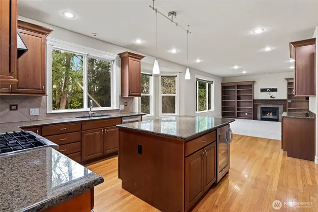 a kitchen with stainless steel appliances granite countertop sink stove and refrigerator