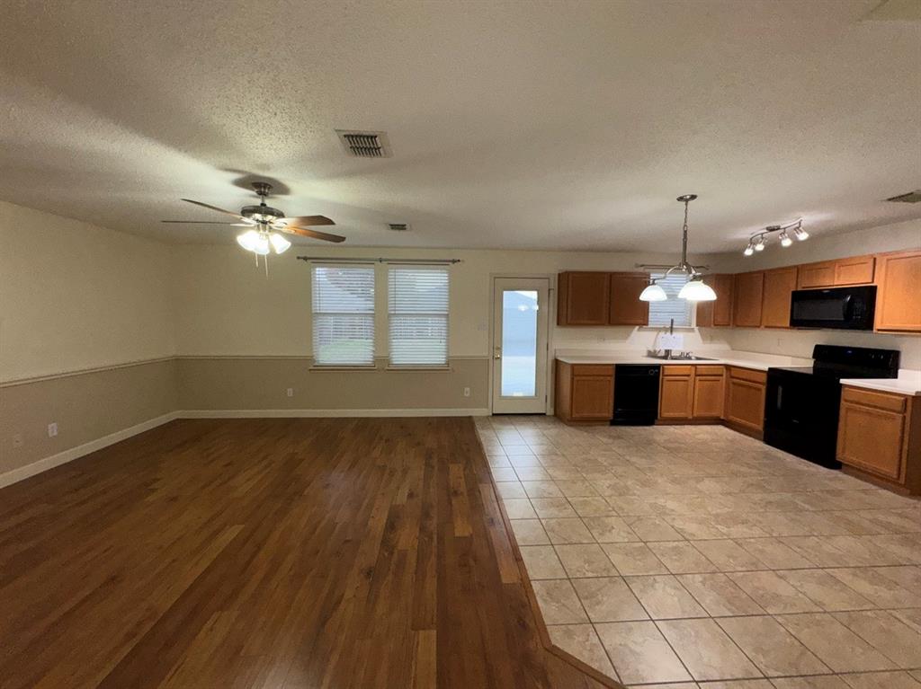 2024 Brazos Court Grand Prairie, TX 75052 - Photo 12 of 40 a large kitchen with granite countertop a stove top oven a sink dishwasher and a fireplace with wooden floor