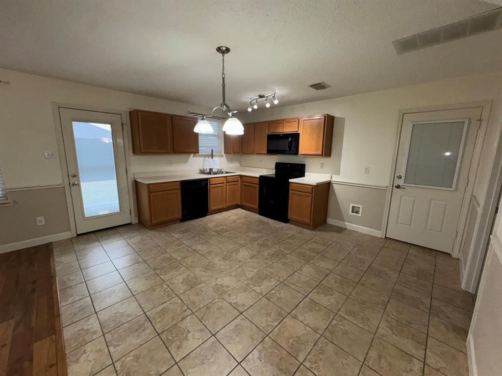 2024 Brazos Court Grand Prairie, TX 75052 - Photo 13 of 40 a kitchen with stainless steel appliances granite countertop a sink and dishwasher a stove top oven with wooden floor