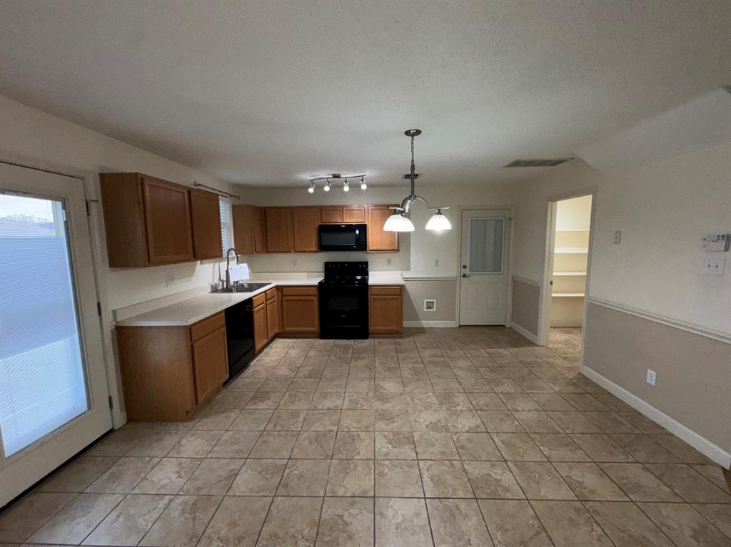 2024 Brazos Court Grand Prairie, TX 75052 - Photo 18 of 40 a large kitchen with cabinets and stainless steel appliances