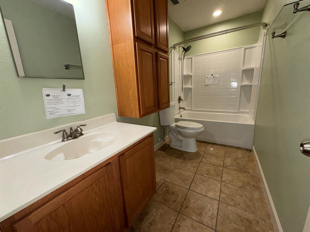 2024 Brazos Court Grand Prairie, TX 75052 - Photo 27 of 40 a bathroom with a sink a toilet and shower