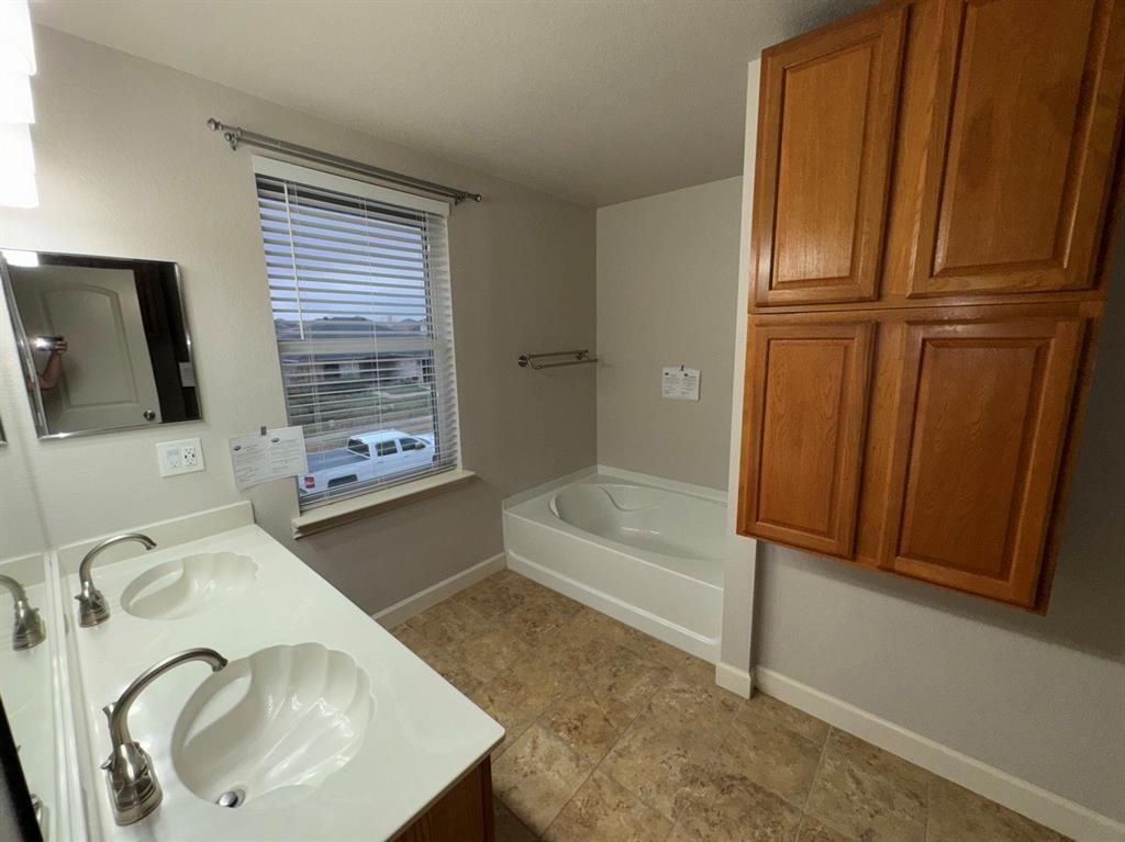 2024 Brazos Court Grand Prairie, TX 75052 - Photo 37 of 40 a bathroom with a sink a bathtub and a mirror